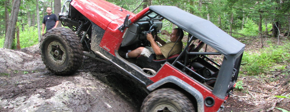 Man driving red Jeep on rocky trail