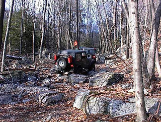 Two Jeeps traversing rocky trail