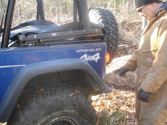 Person checking blue Jeep Wrangler 4x4