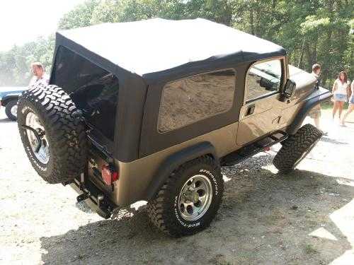 Tan Jeep Wrangler with black soft top