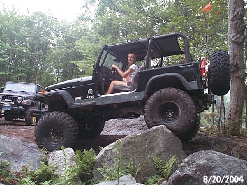 Woman driving Jeep Wrangler on rocks