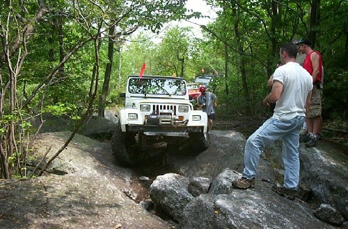 White Jeep navigating rocky terrain