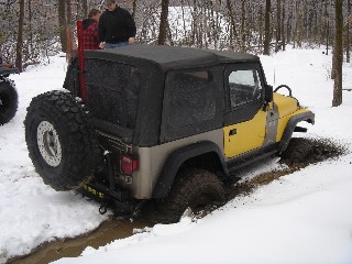 Yellow Jeep stuck in snowy mud