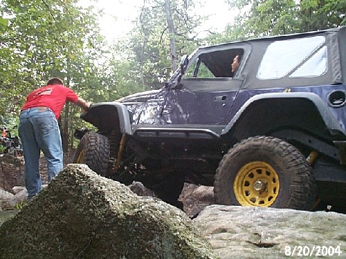 Purple Jeep navigating rocks; off-road adventure