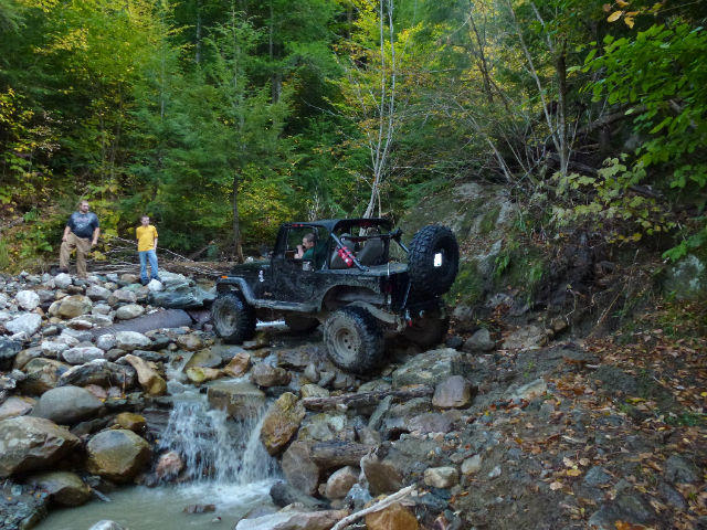 Jeep traversing rocky stream, October run