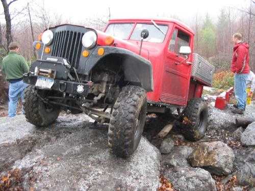 Red Jeep pickup truck off-roading