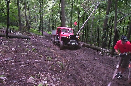 Red truck off-roading on muddy trail