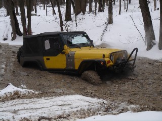 Yellow Jeep stuck in snowy mud