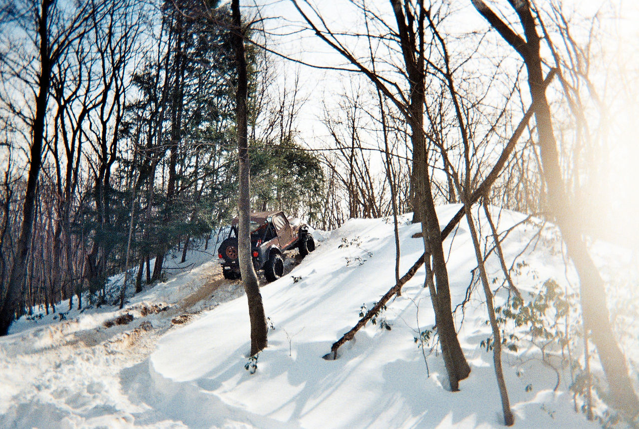 Jeep ascending snowy trail