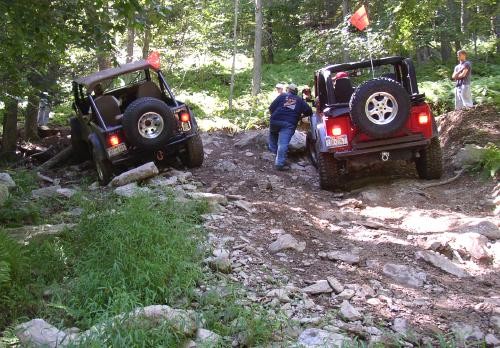 Two Jeeps navigating rocky terrain