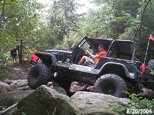 Man driving Jeep over rocks