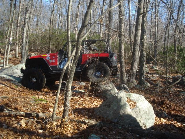 Red Jeep navigating rocky terrain