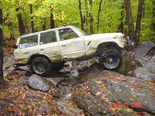 Off-road Toyota Land Cruiser traversing rocky terrain