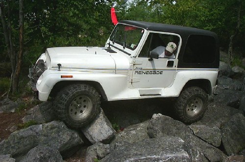 White Jeep Renegade driving over rocks