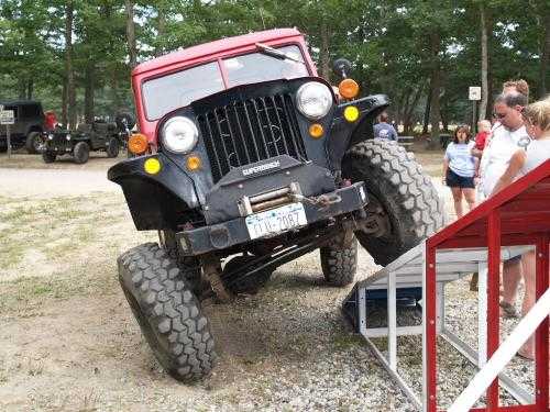 Red Jeep traversing obstacle course