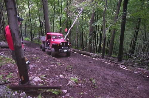Red truck off-roading in woods