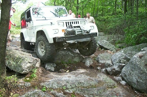 White Jeep navigating rocky terrain