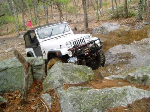 White Jeep navigating rocky terrain