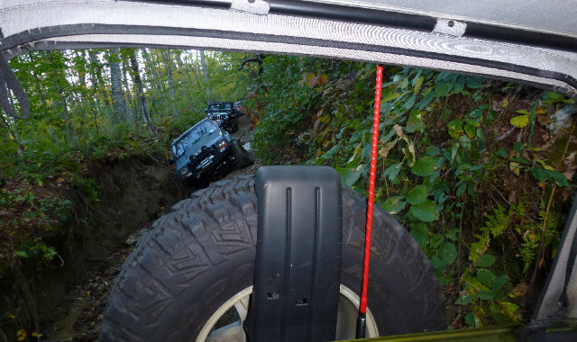 Jeep tire and red antenna, off-road trail