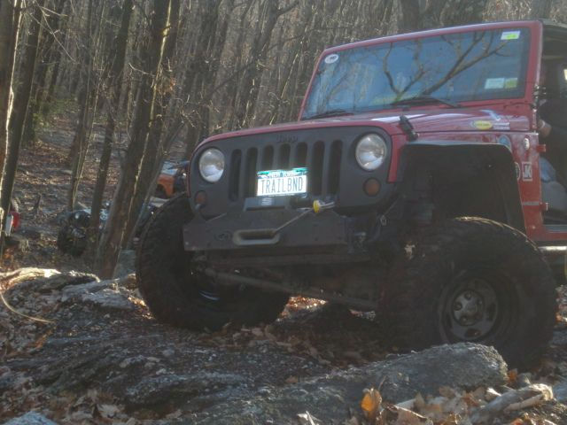 Red Jeep navigating off-road trail
