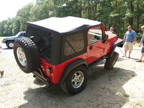 Red Jeep Wrangler with black soft top