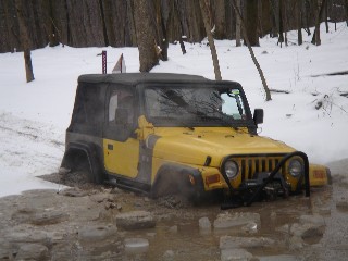 Yellow Jeep stuck in snowy mud