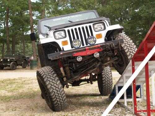 White Jeep Wrangler overcoming obstacle course