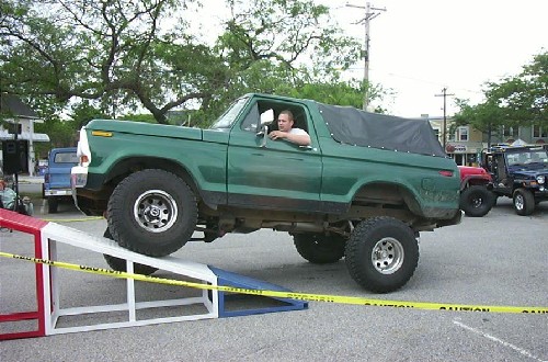 Man driving lifted green Ford Bronco
