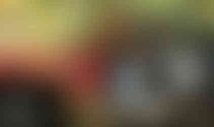 Man driving muddy red Jeep on trail