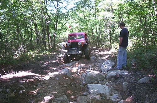 Red Jeep navigating rocky trail