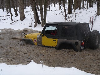 Yellow Jeep stuck in snowy mud