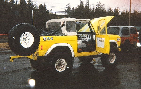 Yellow Ford Bronco, open doors, spare tire