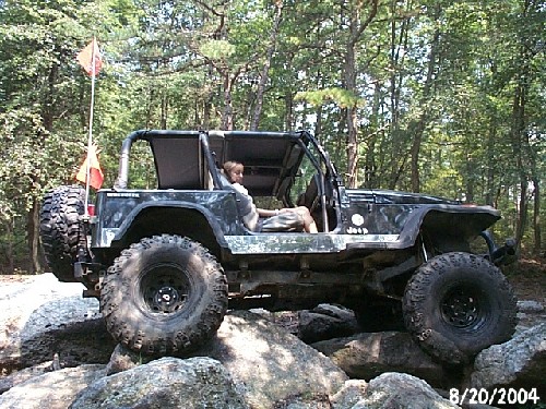 Person driving Jeep on rocks