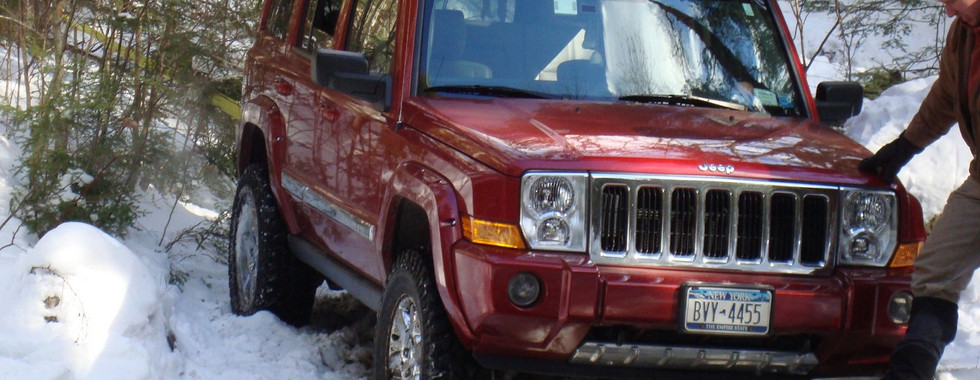 Red Jeep Commander in snowy terrain