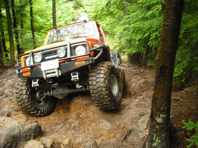 Orange off-road vehicle navigating rocky trail