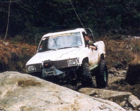White Toyota truck navigating rocky terrain