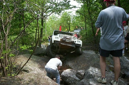 White Jeep stuck on rocks, off-roading