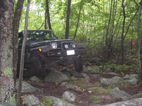 Black Jeep navigating rocky terrain, Long Island Off Road
