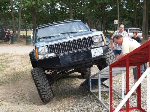 Jeep Cherokee climbing ramp at off-road event
