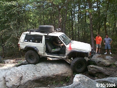White Jeep Cherokee on rocks; off-roading