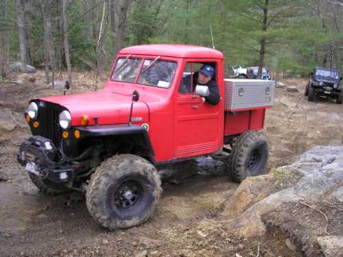 Man in red Jeep truck off-road