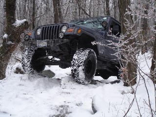 Jeep Wrangler conquering snowy, rocky terrain
