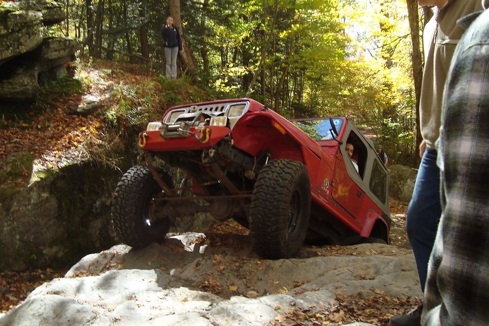 Red Jeep navigating rocky terrain