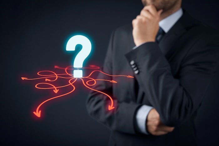 A person in a suit thinking about a question mark