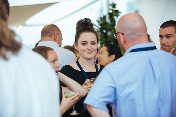 Sami at a conference looking at the camera and smiling
