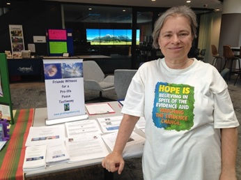 woman standing in from of table at information booth