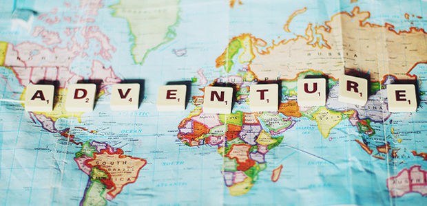 The map of the world with the word ''Adventure'' spelled on it with scrabble letters.