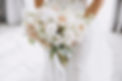 young girl in a white wedding dress holds in her hands a bouquet of flowers and greenery w