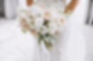 young girl in a white wedding dress holds in her hands a bouquet of flowers and greenery w