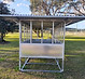 Front view of an extra-high Quast Metal roofed hay feeder with sheet sides and raised feeding table